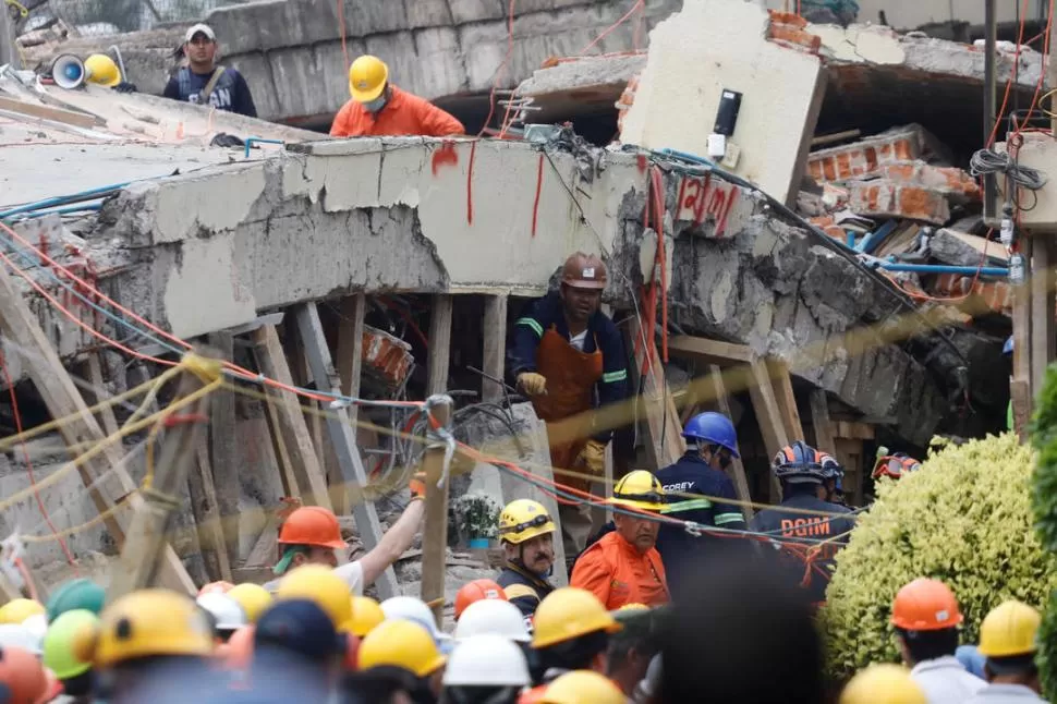 TRABAJO MANUAL. Los rescatistas siguen removiendo escombros. Ya son 273 las víctimas fatales. fotos de reuters