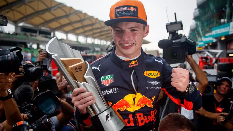 ALEGRÍA JUVENIL. Max Verstappen muestra el trofeo que se adjudicó en Sepang, luego de hacer una gran carrera. Red Bull Content Pool