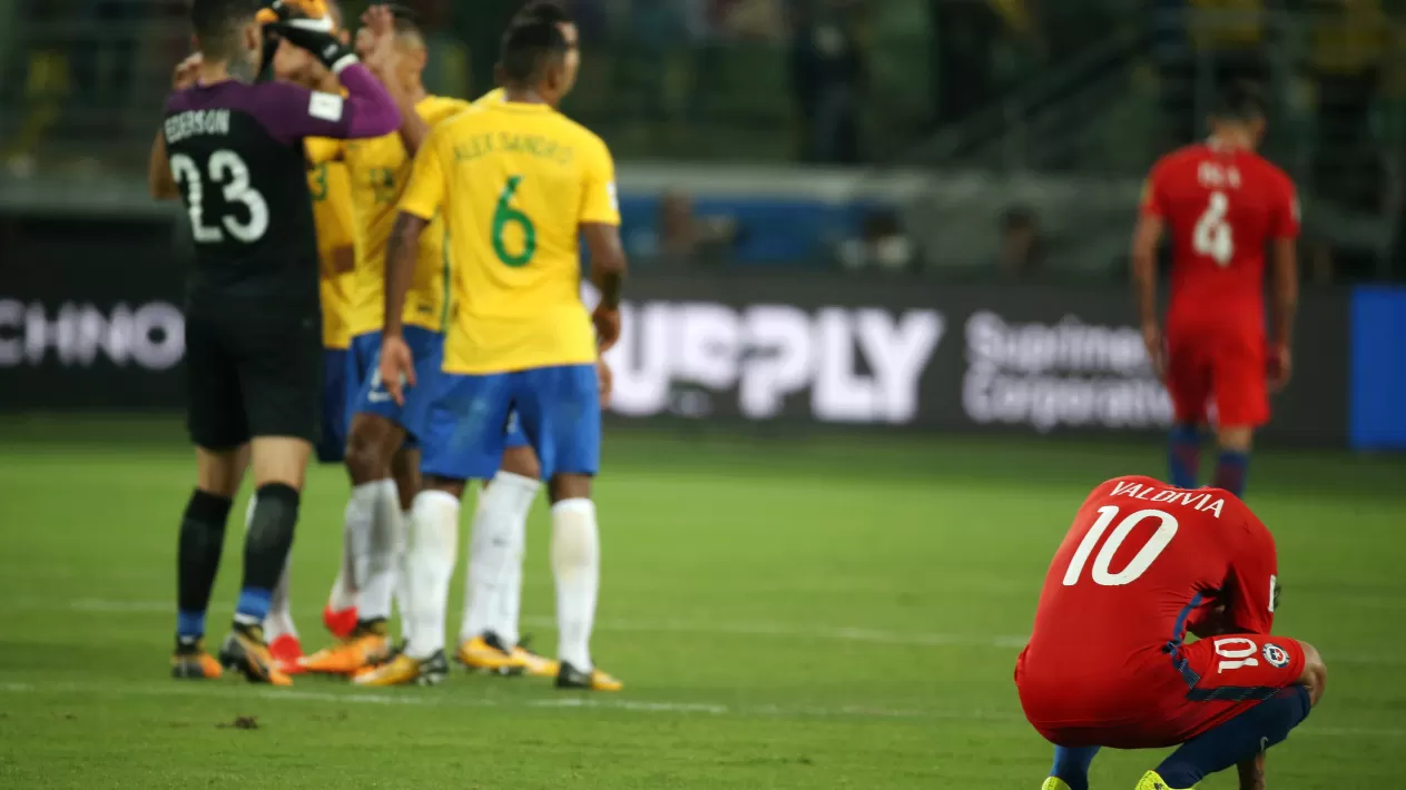 DOLOR. Los jugadores de Chile se lamentan mientras que los brasileños festejan. REUTERS