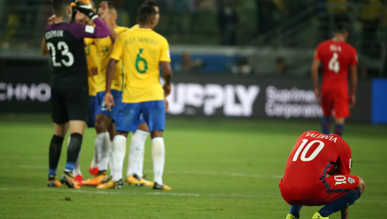 DOLOR. Los jugadores de Chile se lamentan mientras que los brasileños festejan. REUTERS