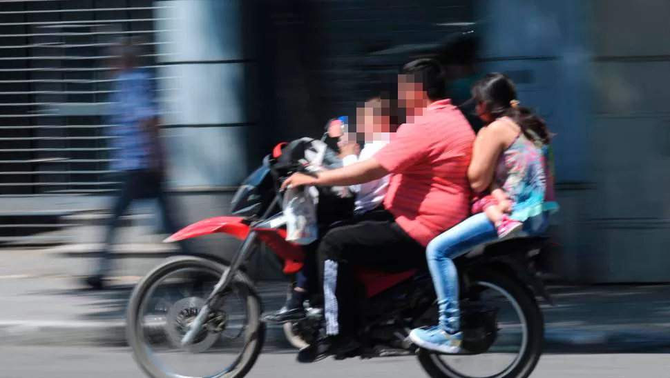 ESCENA REPETIDA EN TUCUMÁN. Un motociclista pone en juego su vida y la de su familia: en el rodado van cuatro personas y ninguna lleva casco. LA GACETA / FOTO DE FRANCO VERA