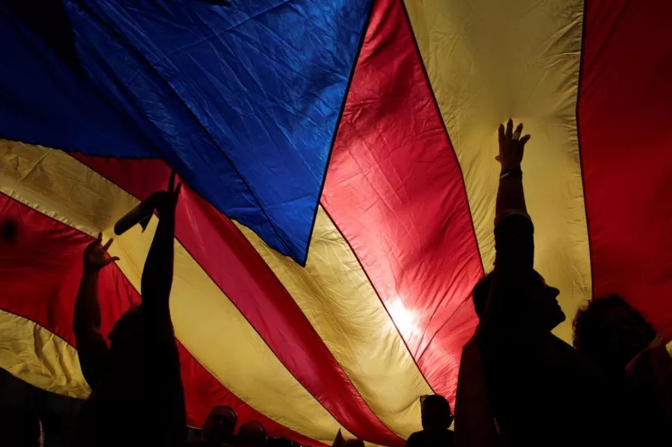SEPARATISTAS. La gente sostiene una gran bandera catalana en una manifestación de los independentistas. reuters 