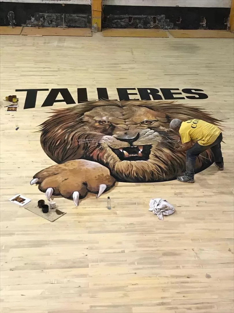 UNA PINTURITA. El artista taficeño “Atilio” termina de pintar el león -apodo de Talleres- en el centro de la renovada cancha. prensa talleres