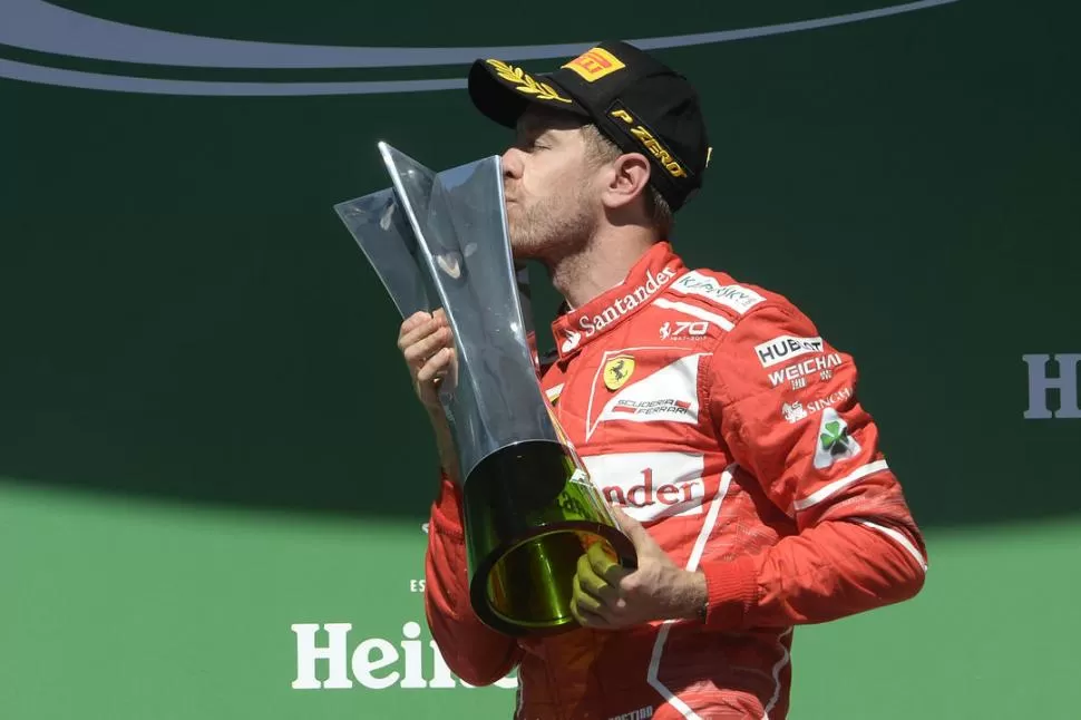 BESO GANADOR. Sebastian Vettel se subió a lo más alto del podio brasileño. prensa ferrari