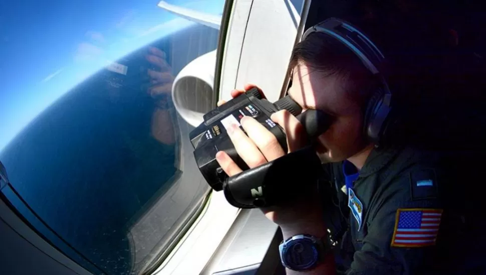 HORAS CRUCIALES. Un experto de EE.UU revisa el océano desde un avión. telam