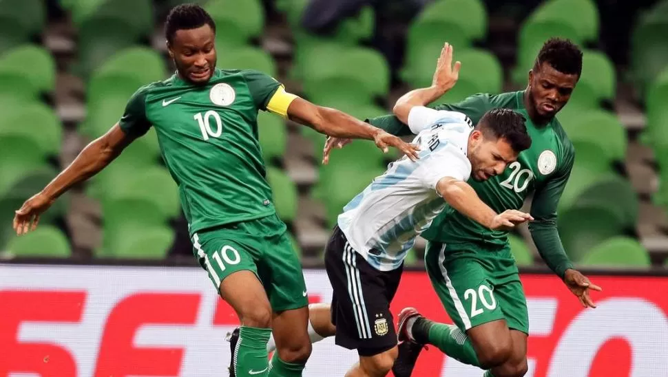 COMPLICADO. Agüero quiere pasar ante la defensa de los jugadores nigerianos en el último amistoso jugado entre ambos. reuters 