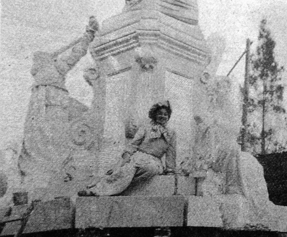LOLA MORA. Encantada, la escultora posa sentada en la base de su monumento a Alberdi. El fotógrafo la captó en Tucumán, en 1904. 