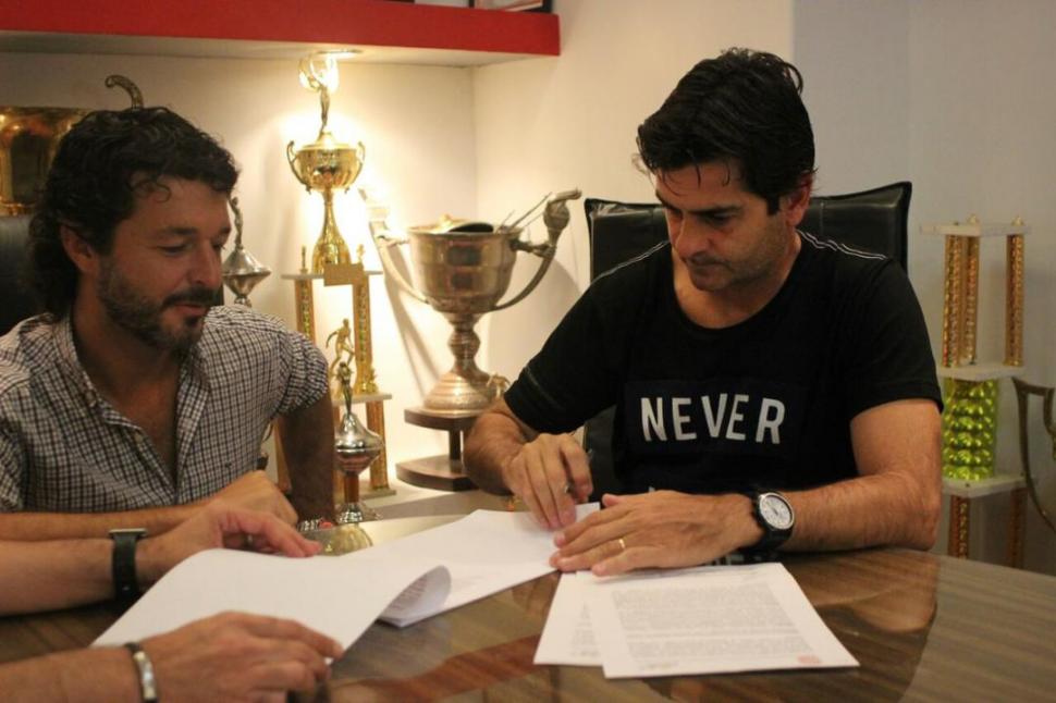 PUSO EL GANCHO. Rubén Forestello firma el contrato que lo liga a San Martín hasta el final del torneo. A su lado, el dirigente Ricardo Seoane observa. prensa casm