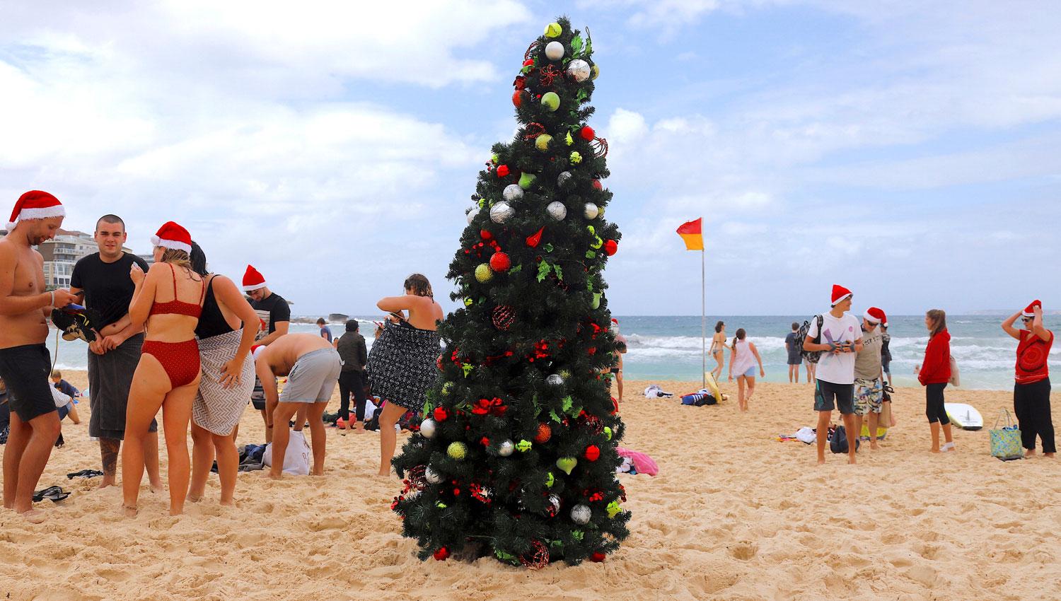 CON CALOR. En Sydney, Australia, muchas personas aprovecharon el buen clima para disfrutar de una Navidad en la playa. REUTERS