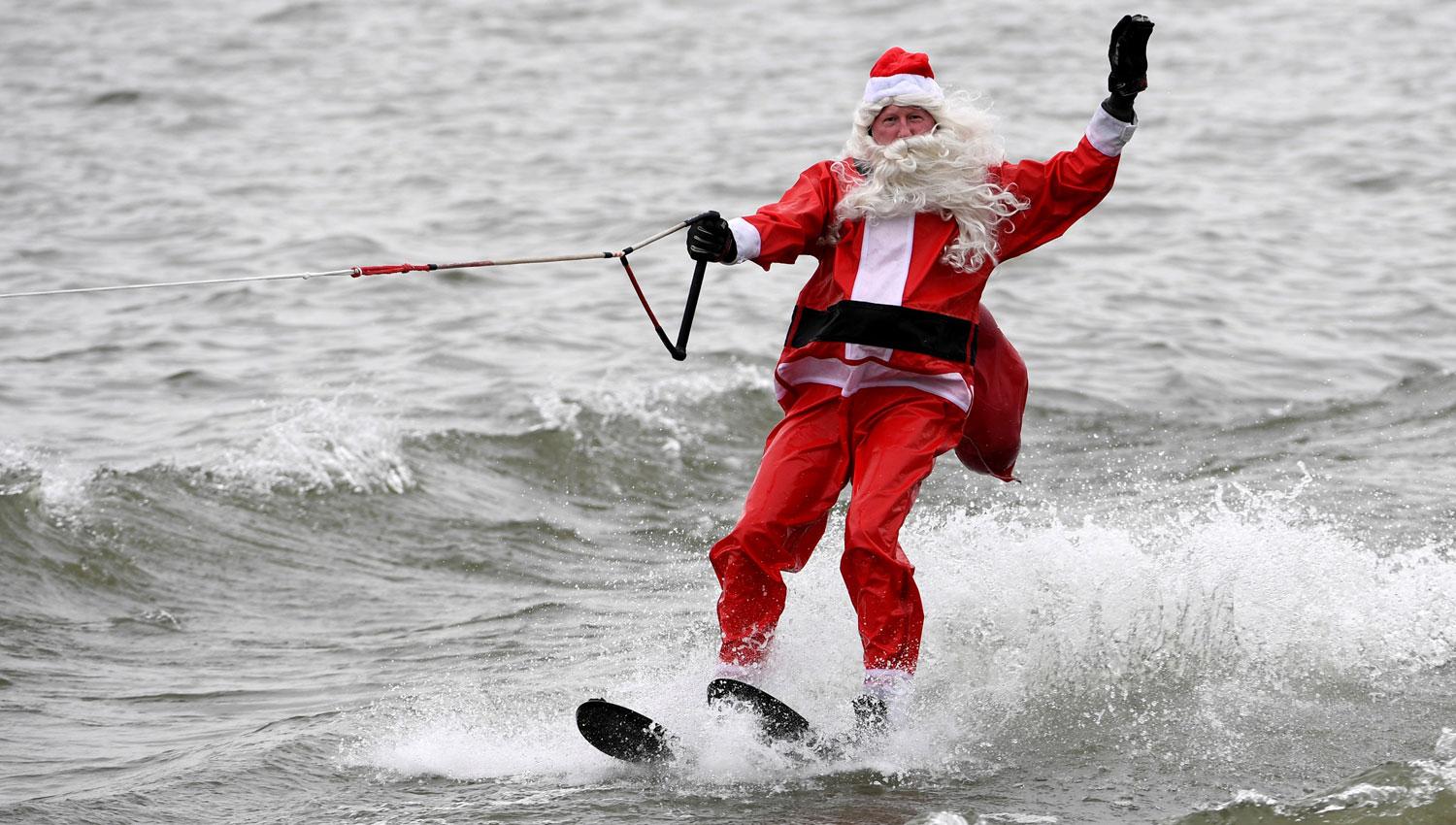 LA TIENE CLARA. Un hombre disfrazado de Papá Noel practicó esquí acuático sobre las aguas del río Potomac, en Virginia, Estados Unidos. REUTERS