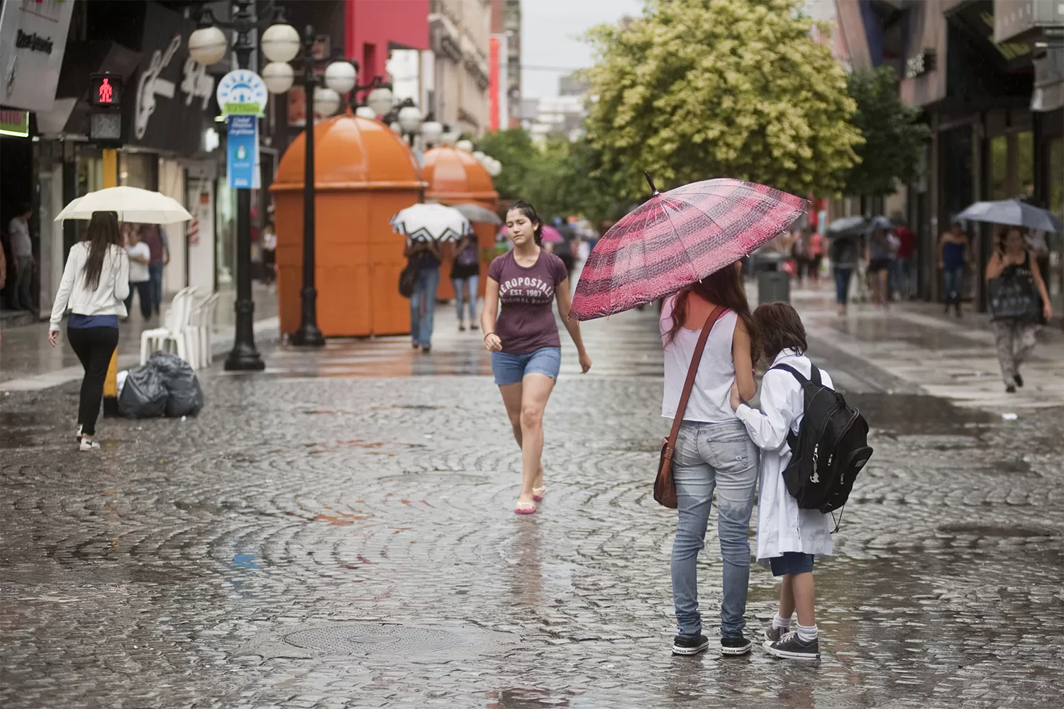 Los tucumanos caminan bajo la lluvia en la peatonal. FOTO ARCHIVO/ LA GACETA.