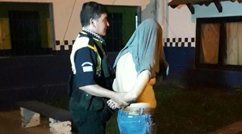 EN LA COMISARÍA. Un policía lleva al joven esposado tras el hecho. foto de ministerio de seguridad