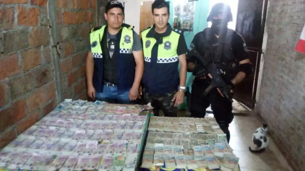 TODO EL SECUESTRO. Los policías exhiben el dinero en efectivo y la droga que incautaron en San Cayetano.  
