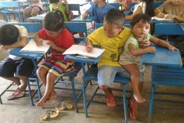 La historia de la foto del niño filipino que estudia con su hermana de un año en brazos