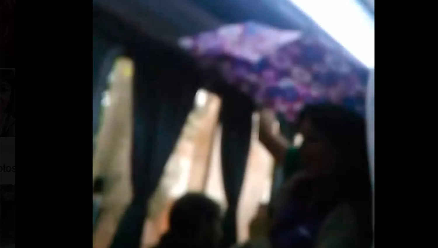ABRIÓ EL PARAGUAS. Una mujer se cubrió del agua que le caída dentro del colectivo. (CAPTURA)