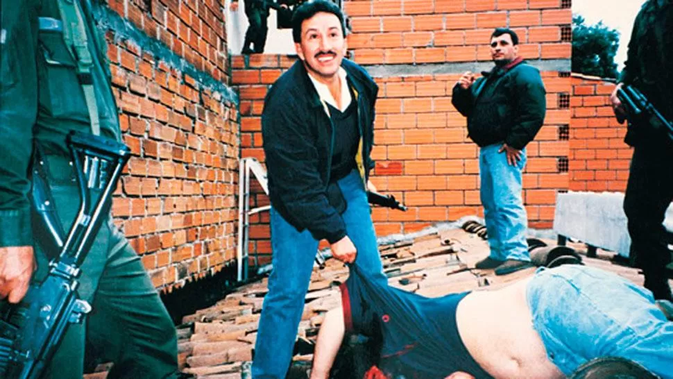 EN EL TEJADO. Hugo Aguilar junto al cuerpo sin vida de Pablo Escobar. FOTO ARCHIVO