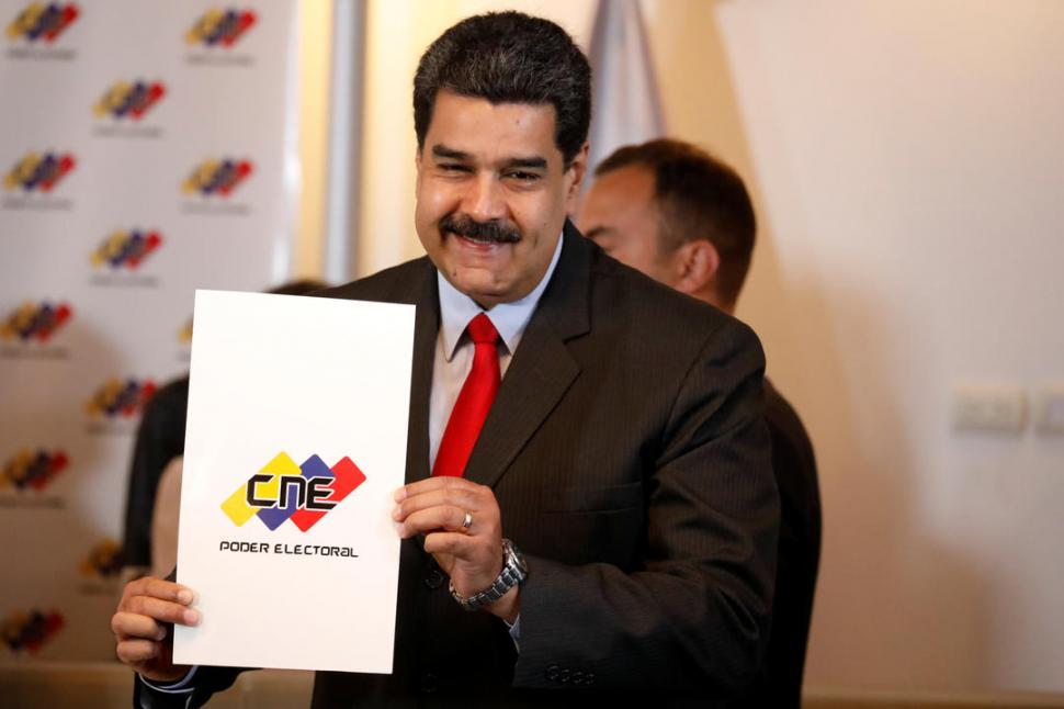 EL PACTO. Maduro muestra la portada del documento que firmó para asegurar el respeto a los comicios. Reuters