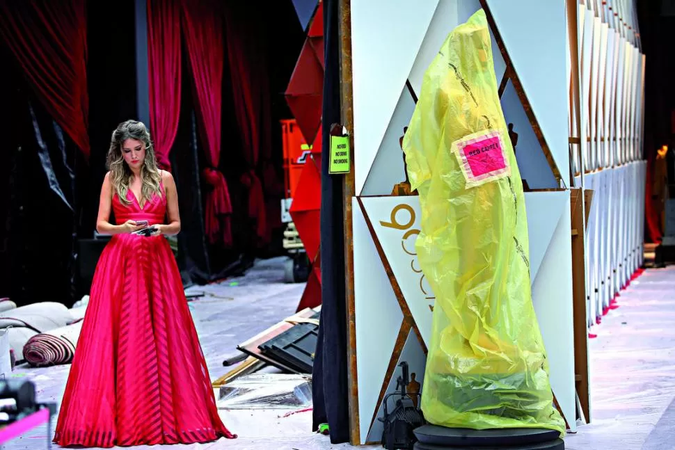UNA DIOSA Y UNA ESTATUA. El detrás de escena y plásticos que cubren Oscar gigantes, todo el ajetreo previo al lujo y la perfección en pantalla.