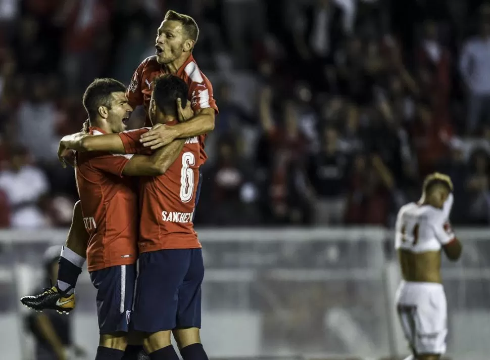FESTEJO. Sánchez Miño y Domingo abrazan a Gigliotti, tras el primer gol. telam