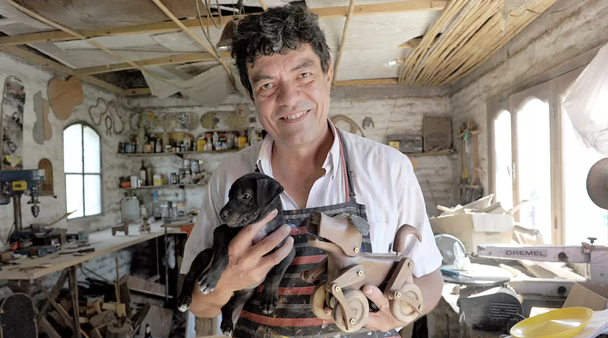 -EN EL TALLER. Alberto Rodríguez, con Piruncho y un perro de madera que hizo con sus propias manos. LA GACETA / FOTO DE FRANCO VERA.