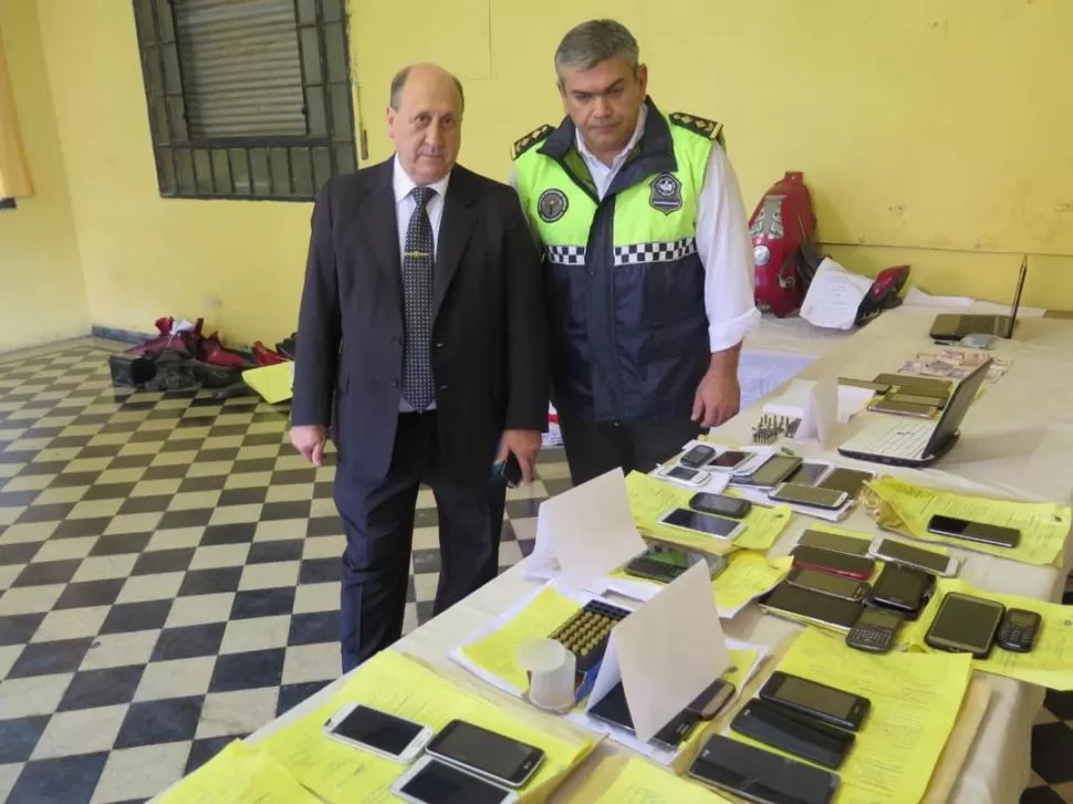 LA PRUEBA. El fiscal Navarro Dávila y el comisario Salvatore exhibieron los teléfonos que fueron incautados. PRENSA MINISTERIO PÚBLICO FISCAL