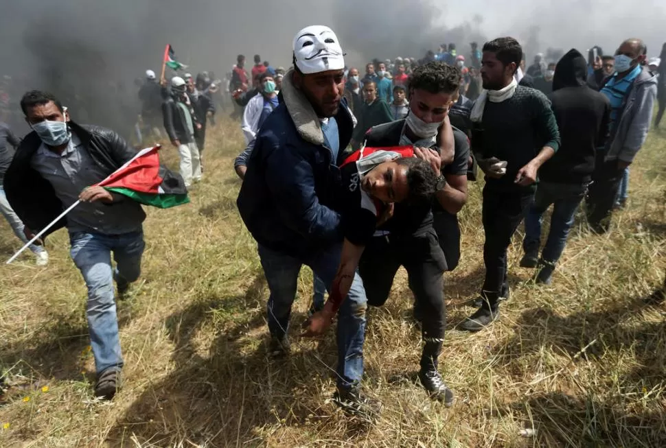 TENSIÓN.  Un manifestante palestino herido es evacuado durante enfrentamientos con tropas israelíes. Reuters