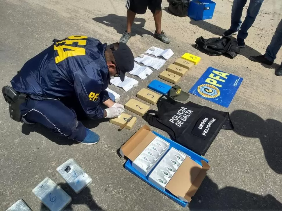 ANÁLISIS DE CAMPO. Un efectivo de la Policía Federal realiza las pericias de rigor a la droga que arrojaron los integrantes de la organización. 