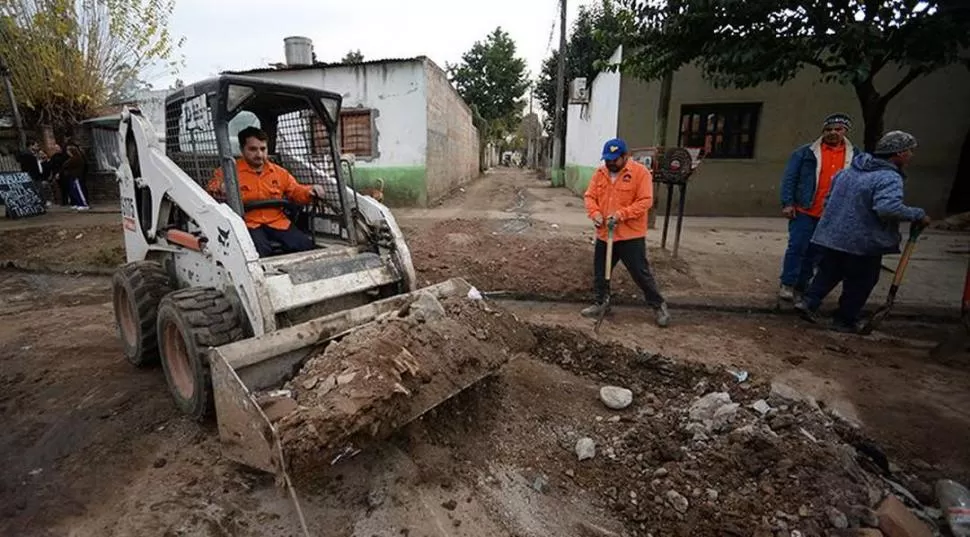 EN LA CAPITAL. Operarios del Ente de Infraestructura trabajan en las veredas del barrio Juan Pablo II (“El Sifón”). prensa 