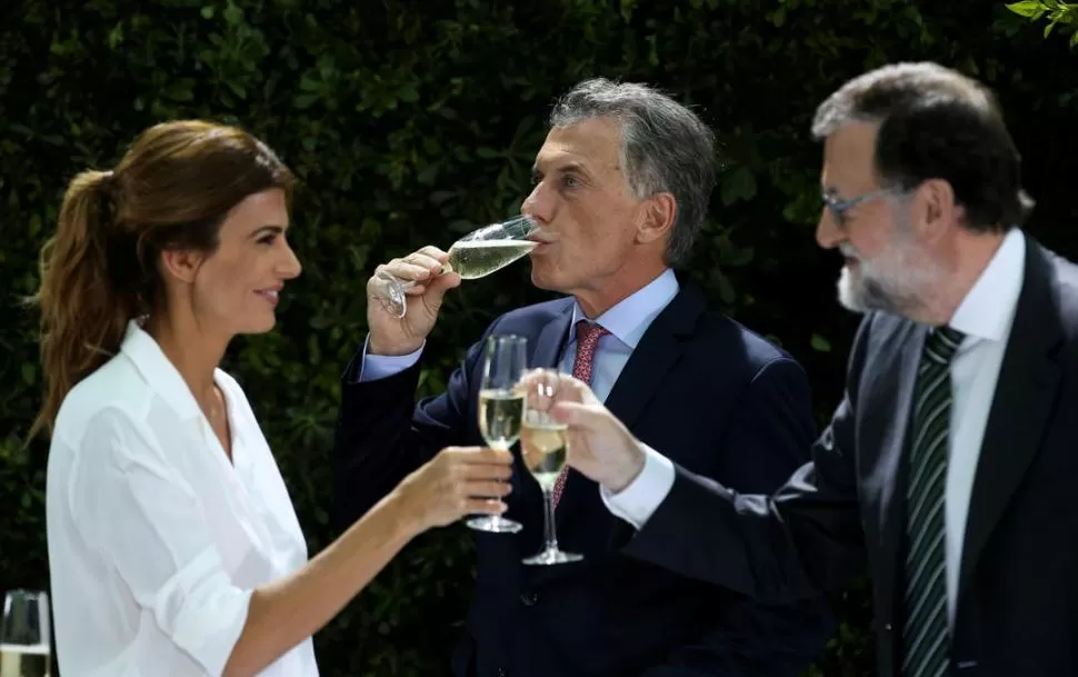 BRINDIS Y COINCIDENCIAS. Rajoy choca su copa con la primera dama, Juliana Awada, tras haber brindado con MacrI en un hotel de Puerto Madero. Reuters