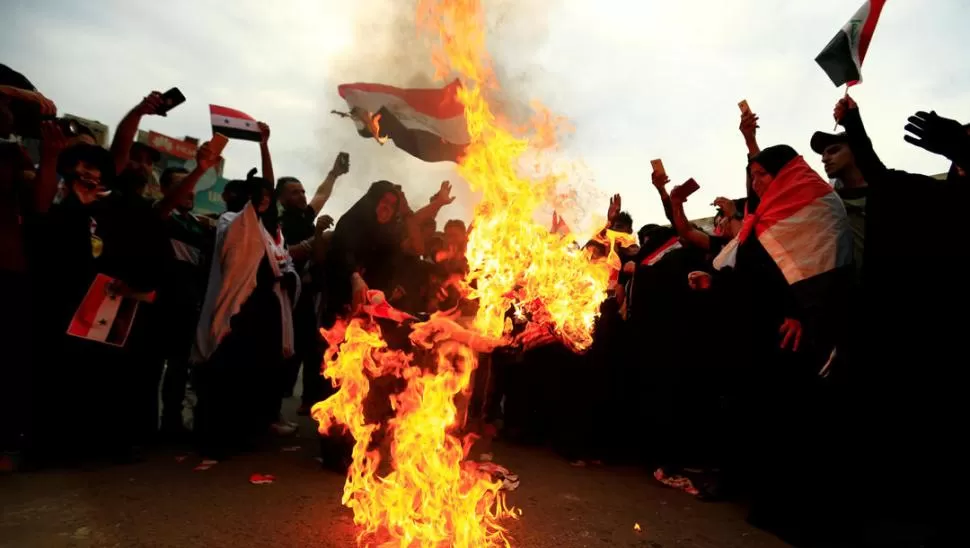 FURIA. Militantes chiítas queman banderas de Estados Unidos en Irak, en protesta por el ataque aéreo a Siria.  fotos reuters 