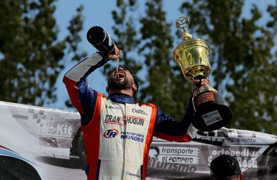 COMO SI FUERA UN TRIUNFO. Maximiliano Bestani celebra en el podio del “Mouras”, con un sorbo de champaña y el trofeo del segundo lugar en la mano. FOTO DE DARÍO GALLARDO 
