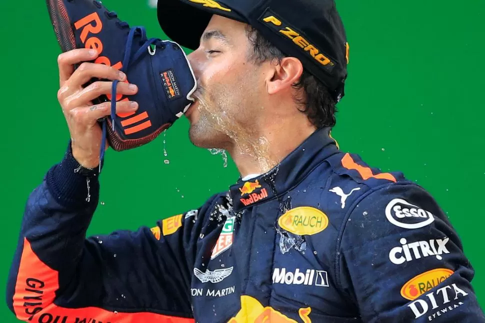 FESTEJO ESPECIAL. Daniel Ricciardo bebe champaña que virtió previamente en su bota; un brindis por demás especial. reuters