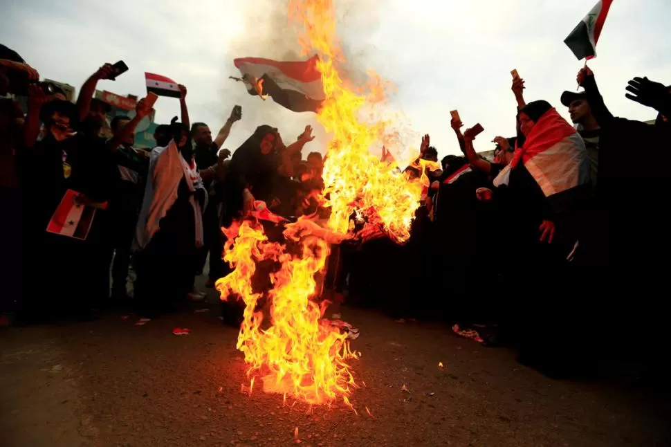 FURIA. Militantes chiítas queman banderas de Estados Unidos en Irak, en protesta por el ataque aéreo a Siria.  fotos reuters 