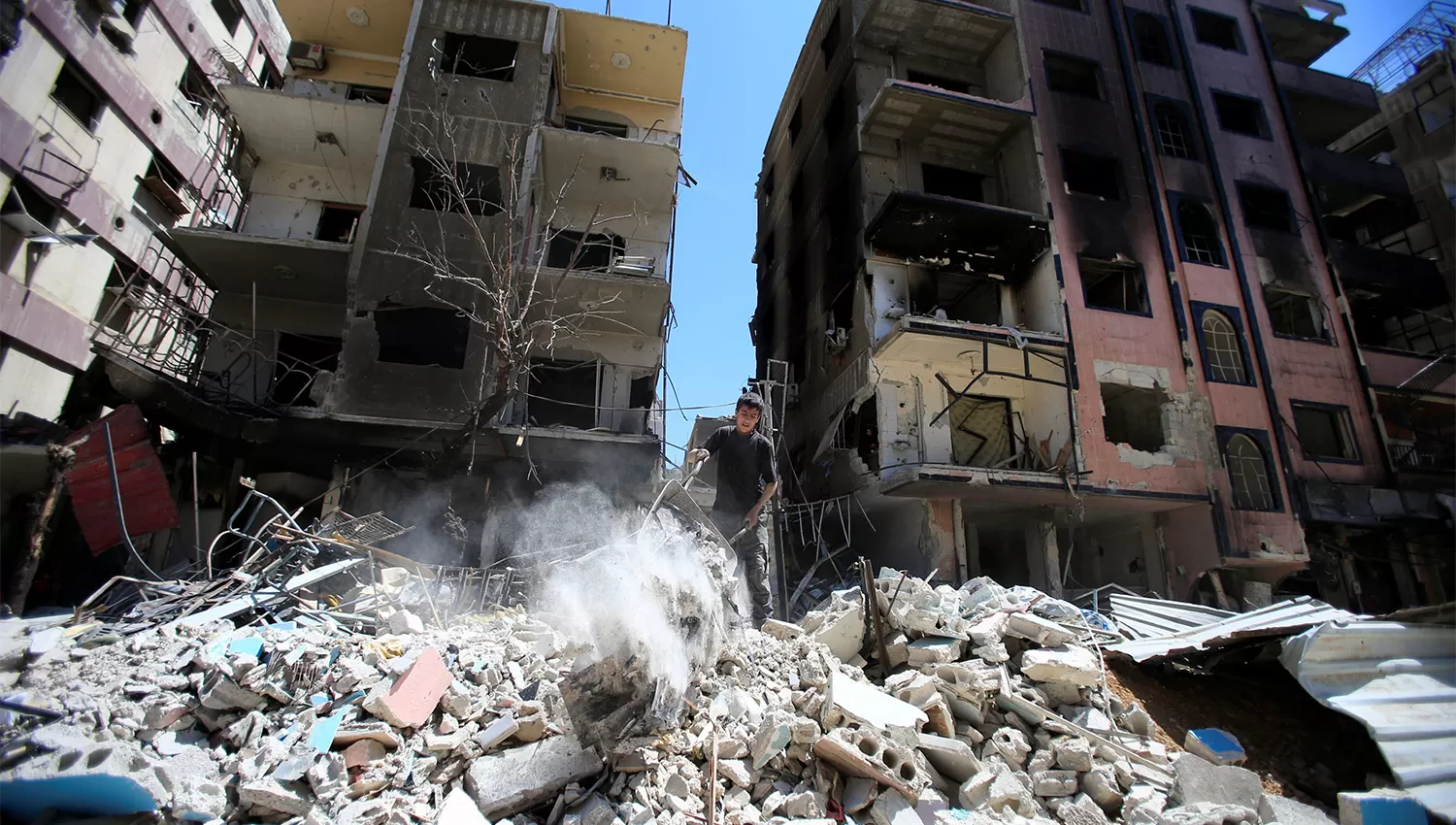 RUINAS. Un chico apila escombros en Duma, a pocos kilómetros de Damasco. REUTERS