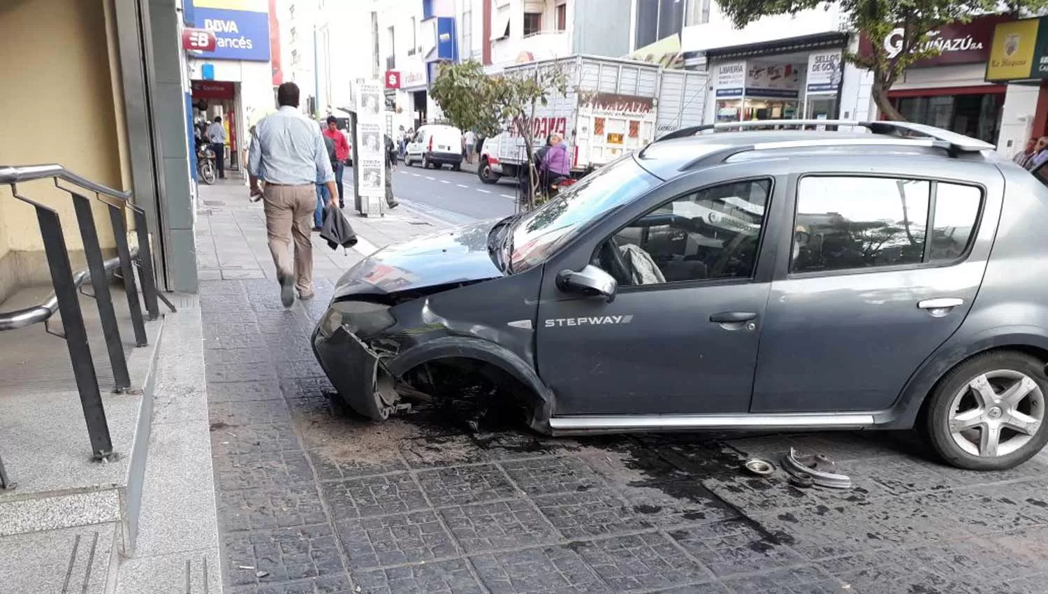 UN SUSTO. El automóvil perdió su rueda delantera izquierda y quedó a metros de la puerta del banco. LA GACETA / FOTO DE ANALÍA JARAMILLO