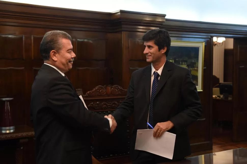 SALUDO. Ricardo Domínguez (CCC) y José Pochat (LA GACETA) se saludan tras firmar el acuerdo. LA GACETA / FOTO DE DIEGO ARÁOZ.-