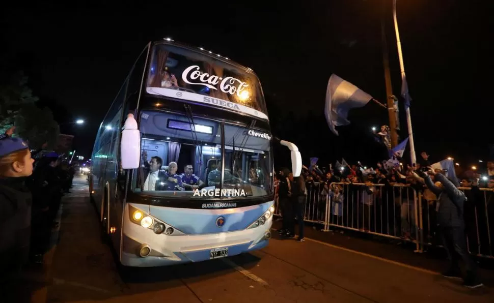 LA ESPERANZA, EN MARCHA. El micro que trasladó a la delegación argentina hasta el aeropuerto de Ezeiza fue rodeado por niños, mujeres y hombres que saludaron y brindaron su apoyo a los futbolistas. reuters