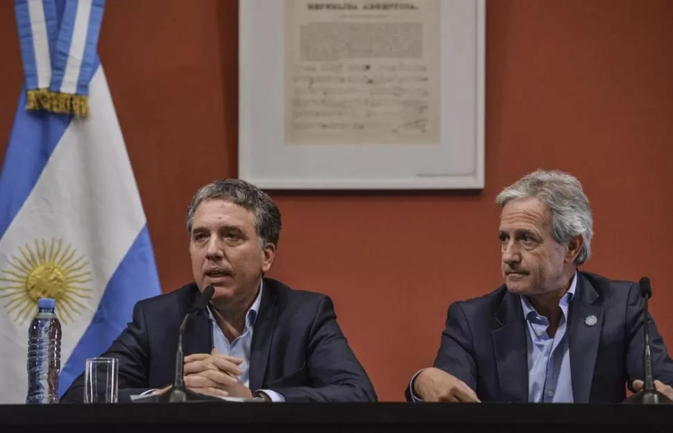 EL ANUNCIO. Nicolás Dujovne y Andrés Ibarra cuentan los detalles del paquete de medidas que comenzará a implementarse en el Estado nacional. telam