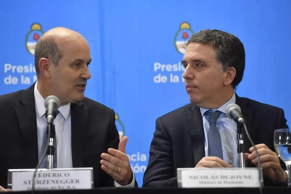 ANUNCIO. Federico Sturzenegger y Nicolás Dujovne aseguraron el jueves que el préstamo del FMI ayudará a reducir el déficit fiscal en dos años. TELAM.