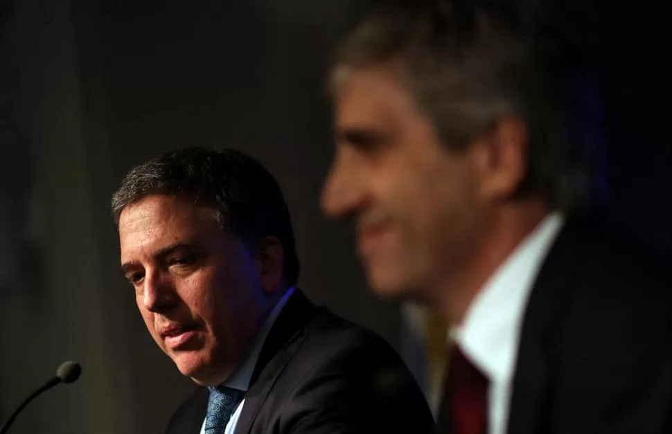 ANUNCIOS. Dujovne (izquierda), con el nuevo jefe del Central, Luis Caputo, en la conferencia de prensa. Reuters
