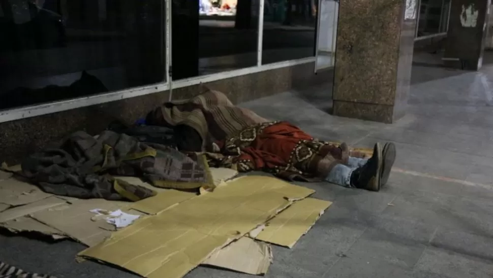 NOCHES DE ESPERA. Dos personas duermen a metros de la puerta de la Anses; lo hacen para obtener un turno que les permita realizar trámites.LG PLAY