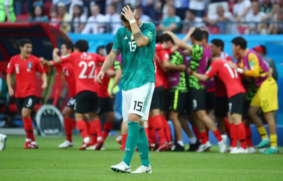 LAS DOS CARAS. Mientras Niklas Süle se lamenta por la derrota alemana, los coreanos dan rienda suelta a su algarabía.  reuters