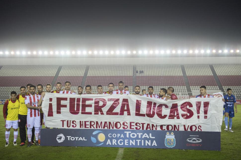 VAMOS TODAVÍA. Los jugadores de San Martín ingresaron al campo de juego portando una bandera en apoyo a Lucas Diarte. 