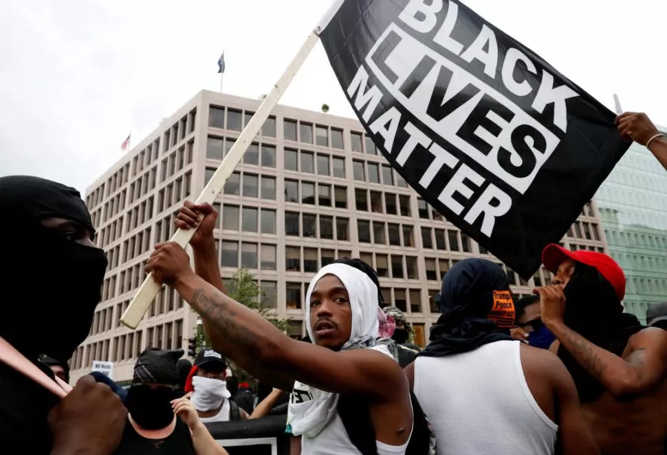 RECLAMO. Afroamericanos llevaron banderas con reclamos como “las vidas de los negros sí importan”.  reuters