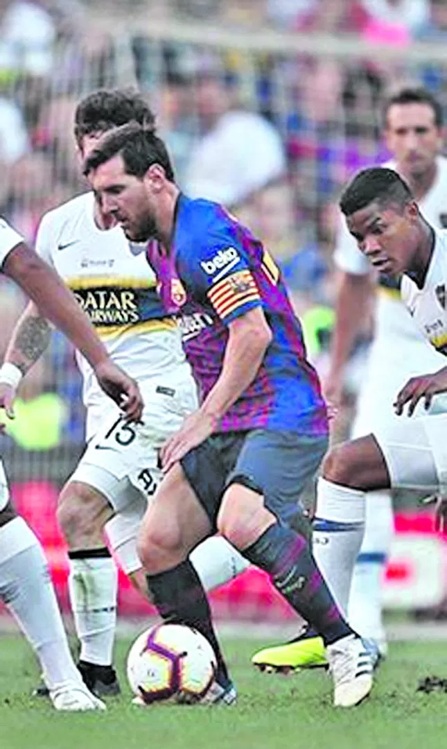IMPARABLE. Messi domina el balón rodeado por jugadores de Boca. prensa cabj