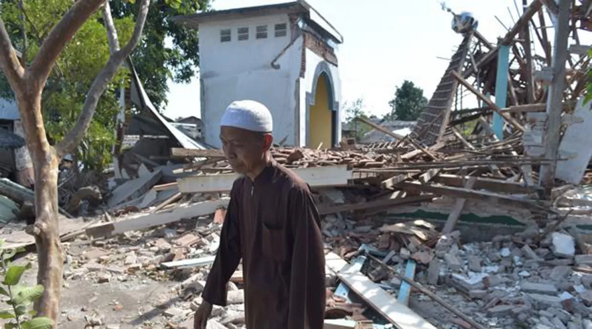 LOMBOK. Un hombre pasa por delante de varios edificios derribados por el terremoto 