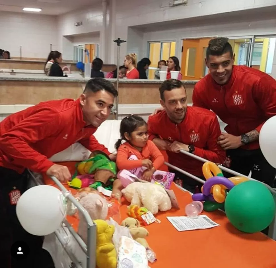 ¡QUÉ MOMENTO! Bieler, Altuna y Acevedo posan con una nena luego de entregarle su regalo. Los jugadores robaron sonrisas. prensa casm