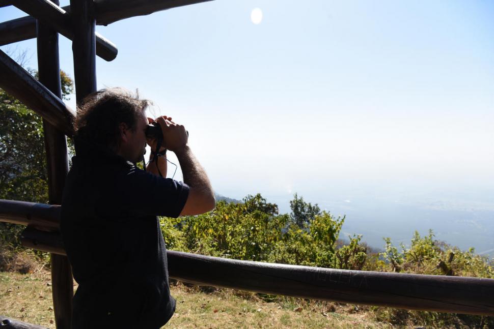 MIRADOR. Un hombre observa la llanura tucumana desde el cerro. 