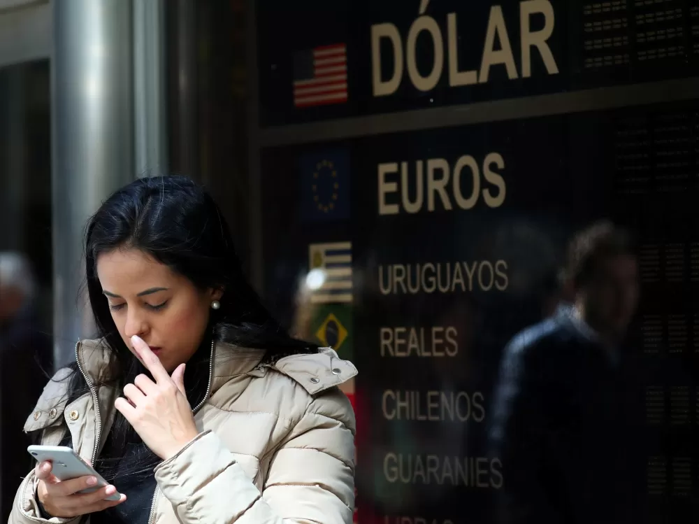 HACIENDO CÁLCULOS. Los argentinos siguen apostando al dólar como refugio de ahorros ante la crisis. 