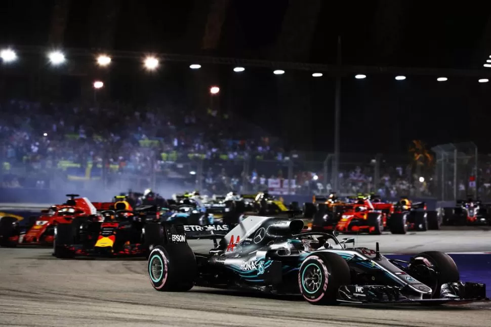 ESPECIE DOMINANTE. El Mercedes de Lewis Hamilton avanza decidido en el trazado urbano de Marina Bay, con todo el “malón” de coches por detrás; el triunfo del británico resultó inobjetable. Foto Prensa Pirelli